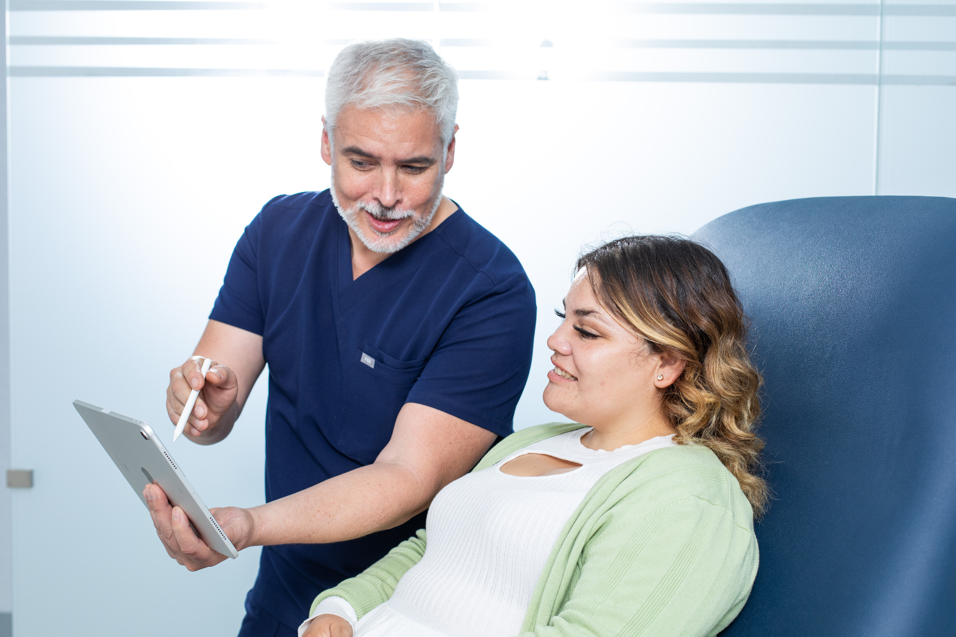 Dr. Ariel Ortiz reviewing information on a tablet with a patient during a consultation.