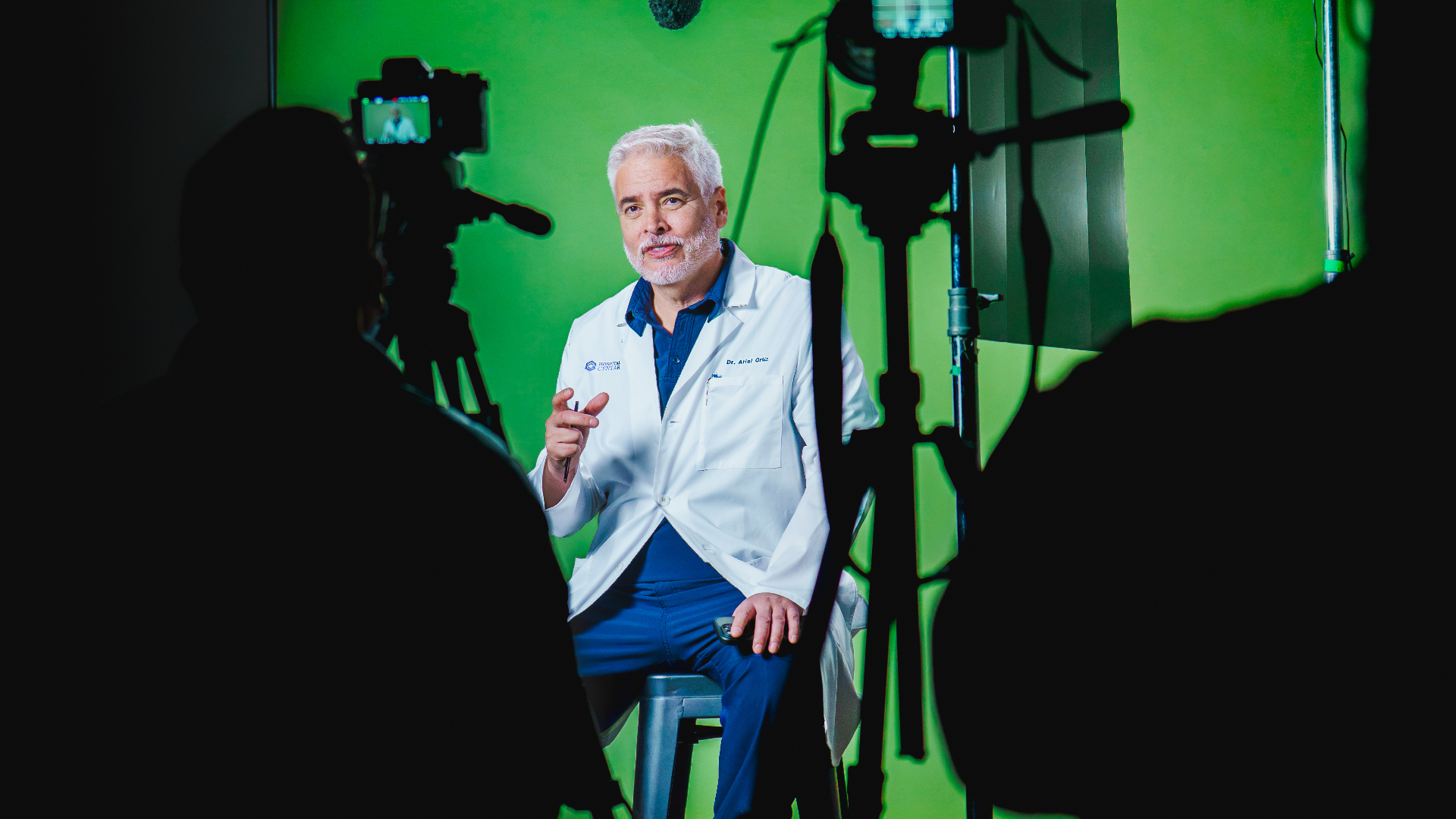 Dr. Ariel Ortiz in the operating room watching the laparoscopic monitor during a live surgical broadcast.